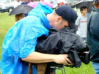 Camera Man Keeping His Equipment Dry